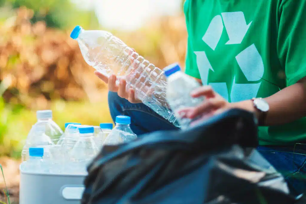 uomo che ricicla le bottiglie di plastica